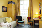 Photograph of a room with chairs, desk and cupboard