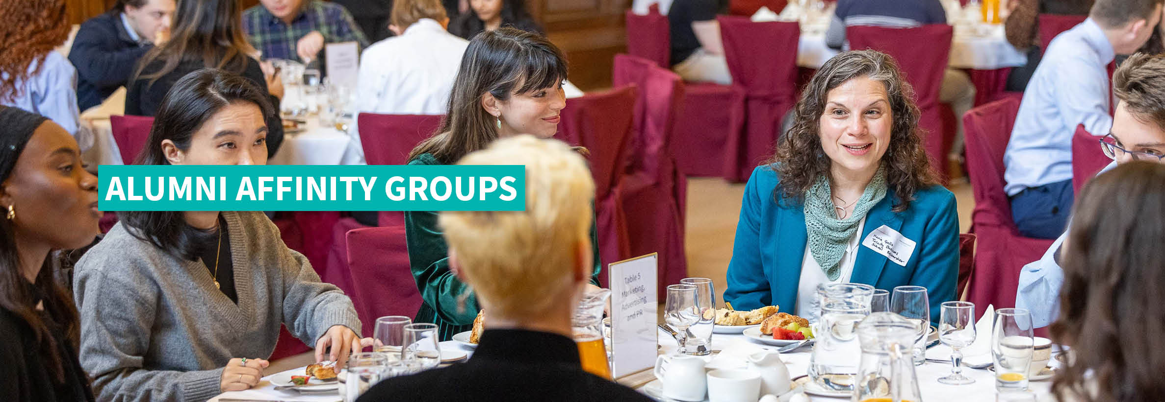 Group of alumni enjoying dinner and discussion at an alumni social event