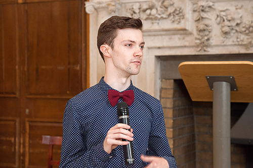 Image of Alexander Fay at Trinity College, wearing a dark blue shirt and burgandy dickie-bow tie