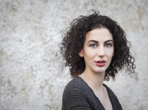 Breffni Holohan, profile photograph in front of pebble-dash wall.